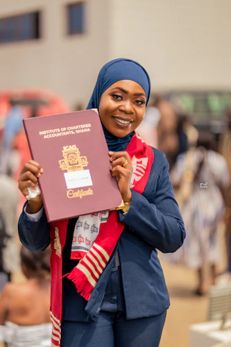 Rukayya's Graduation Holding up Certificate by Yushahu Yussif Azara
